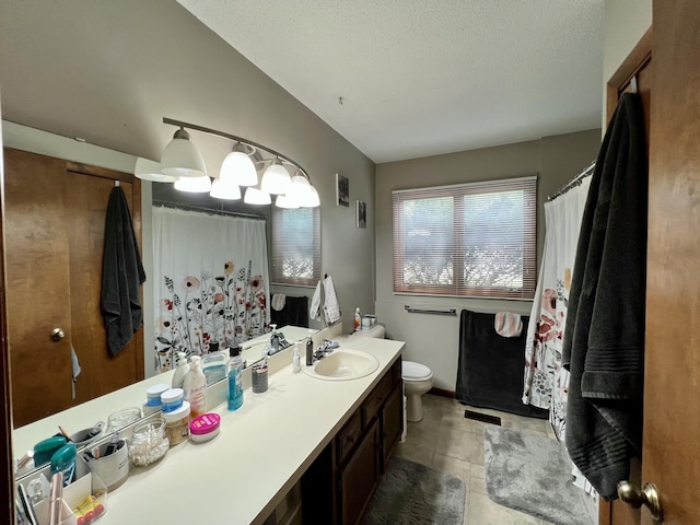 full bathroom with vanity, toilet, and a textured ceiling