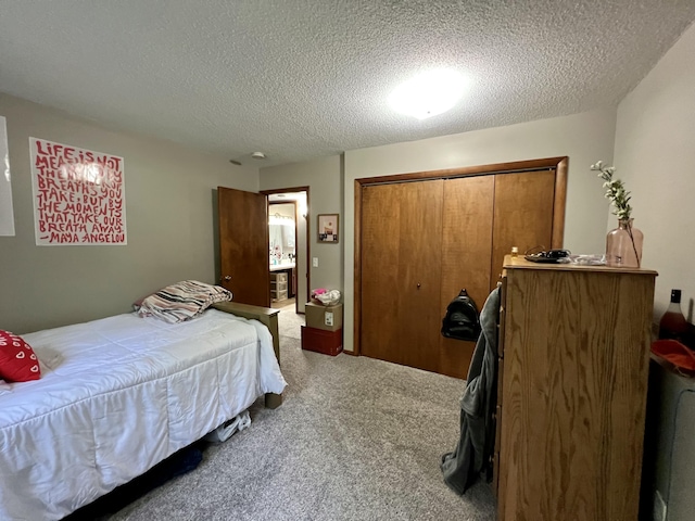 bedroom with a closet, light carpet, and a textured ceiling