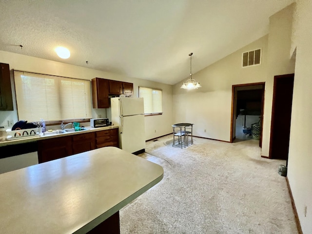 kitchen with light carpet, visible vents, freestanding refrigerator, light countertops, and pendant lighting