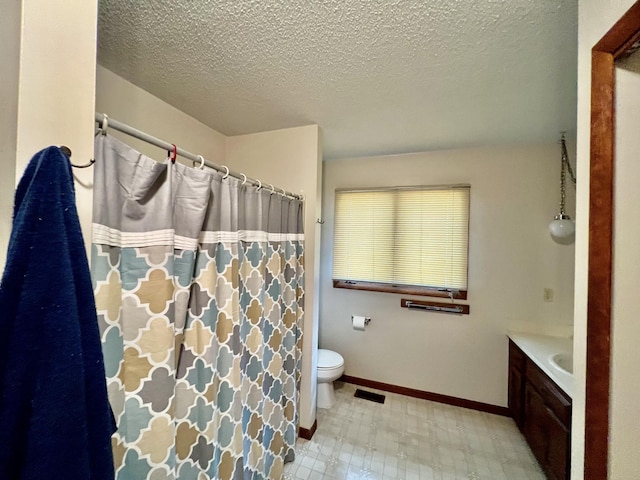 full bathroom with baseboards, toilet, tile patterned floors, a textured ceiling, and vanity