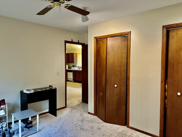 bedroom featuring light colored carpet, ceiling fan, and baseboards