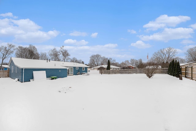 yard covered in snow with a garage and fence