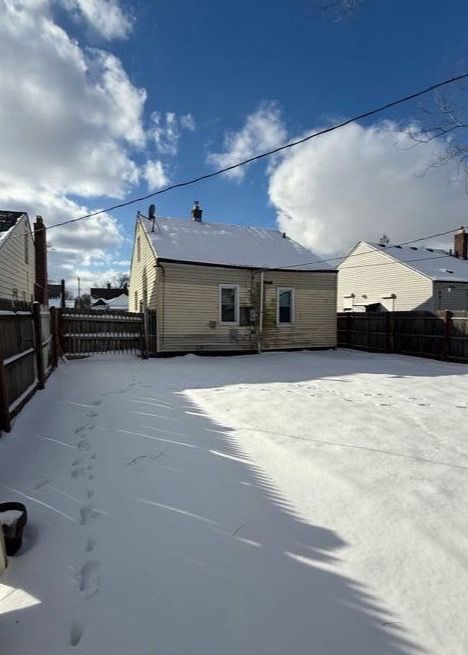 rear view of house featuring fence