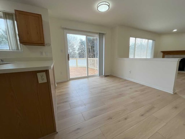 unfurnished dining area featuring light wood-style flooring and baseboards