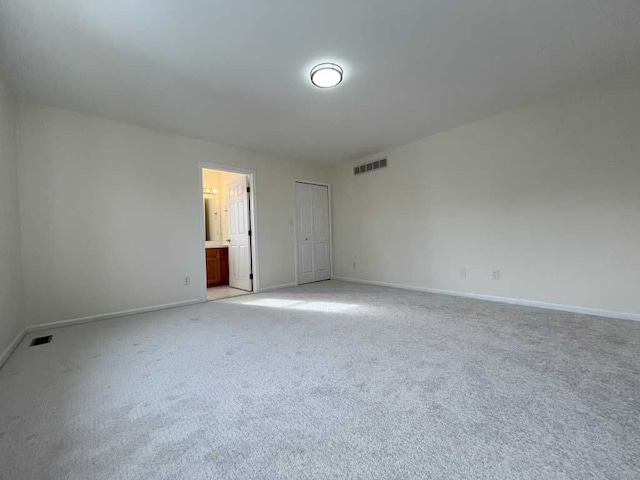 spare room with light carpet, visible vents, and baseboards