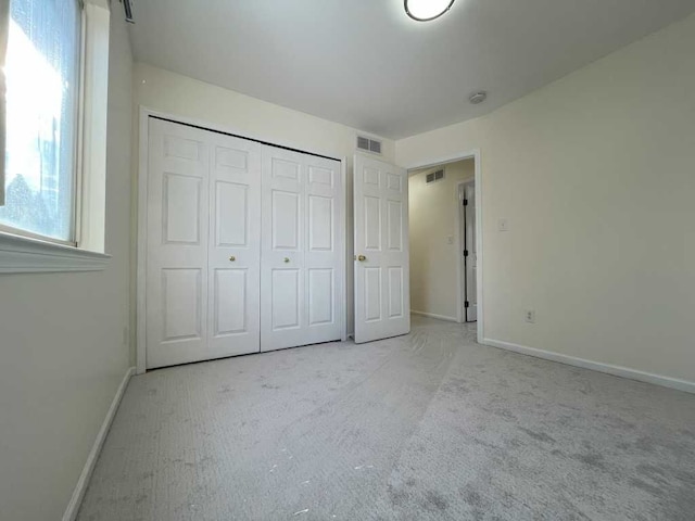 unfurnished bedroom featuring a closet, visible vents, and baseboards