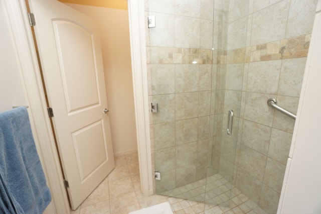 bathroom with tile patterned floors and a shower stall