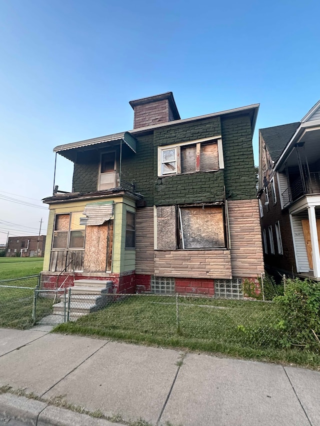 view of front facade with fence and a front lawn