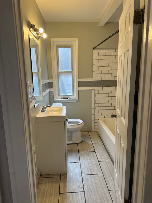 full bathroom with  shower combination, wood finish floors, vanity, and toilet