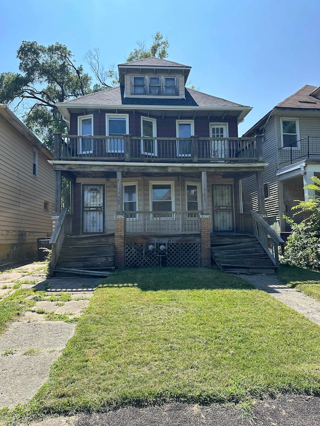 traditional style home with a porch, a front yard, and a balcony