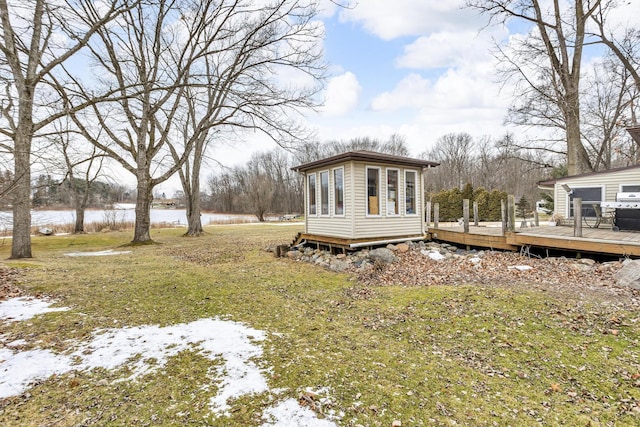 view of yard with an outbuilding and a deck with water view