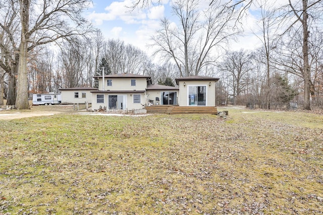 back of house featuring a wooden deck and a yard