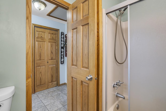 bathroom with  shower combination, toilet, and tile patterned floors