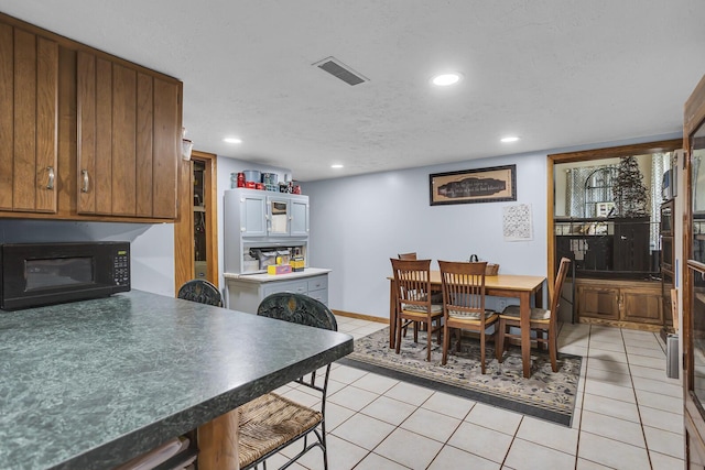 dining area with light tile patterned floors, visible vents, and recessed lighting