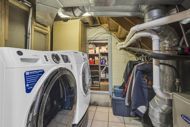 laundry room with concrete block wall, laundry area, washing machine and dryer, and tile patterned floors