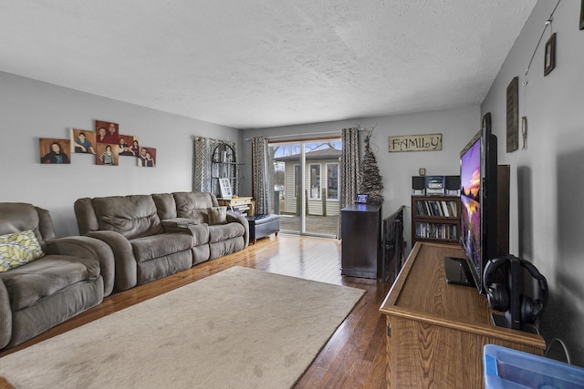 living area featuring a textured ceiling and hardwood / wood-style floors