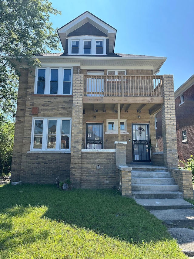 view of front facade featuring covered porch, brick siding, a front lawn, and a balcony