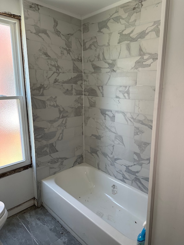 bathroom with marble finish floor, toilet, and a tub