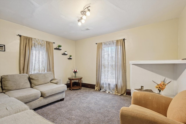 living room with a textured ceiling, carpet, visible vents, and baseboards