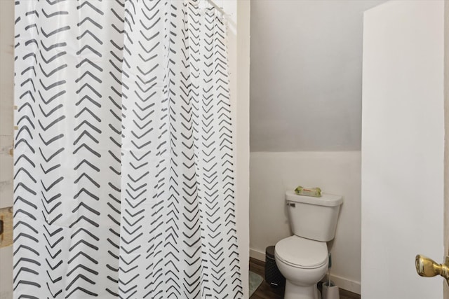 full bathroom with toilet, lofted ceiling, baseboards, and a shower with shower curtain