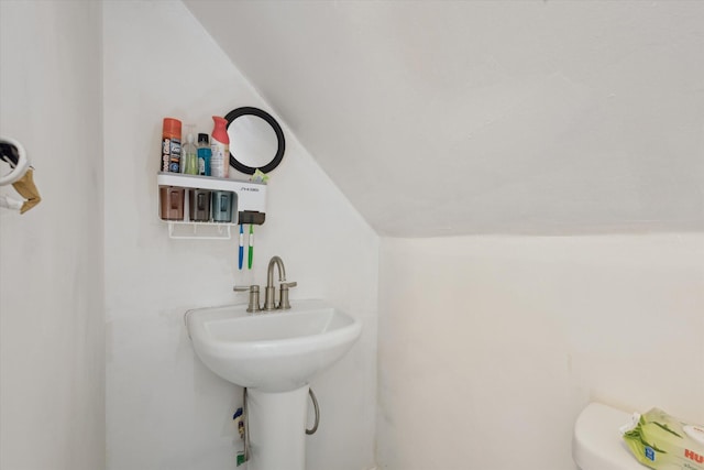 bathroom featuring vaulted ceiling and a sink