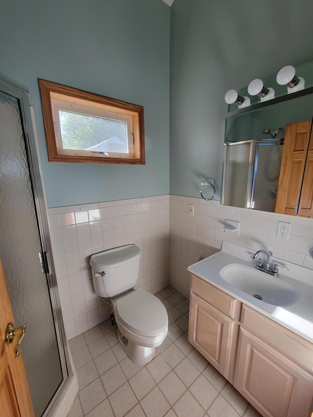 bathroom featuring a stall shower, tile patterned flooring, tile walls, and vanity