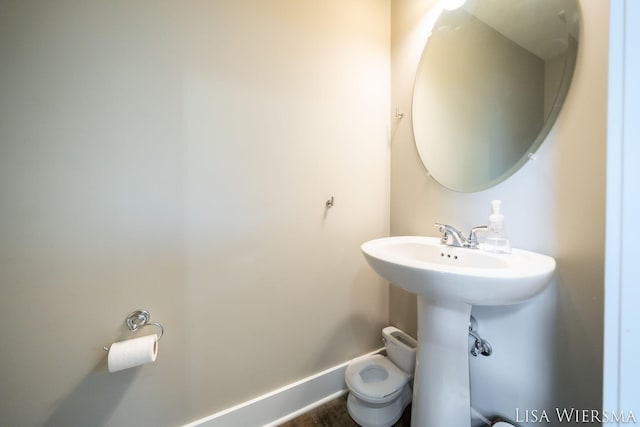 half bathroom with toilet and baseboards