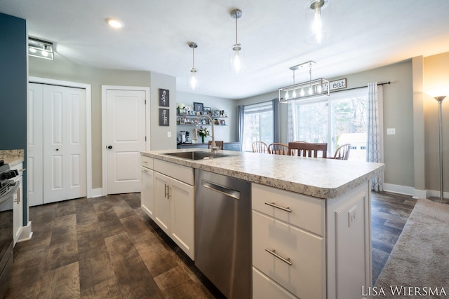 kitchen with stainless steel appliances, white cabinets, a kitchen island with sink, and decorative light fixtures