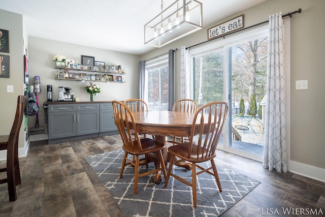 dining room with a chandelier, dark wood finished floors, and baseboards