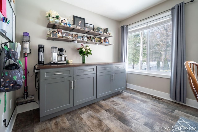 bar with visible vents, baseboards, and dark wood-style flooring