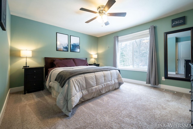 bedroom with baseboards, ceiling fan, visible vents, and light colored carpet