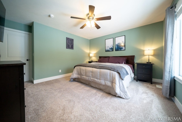 bedroom with light colored carpet, ceiling fan, and baseboards