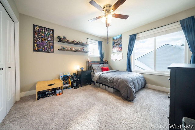 carpeted bedroom with a ceiling fan, a closet, and baseboards