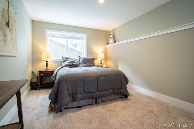 bedroom featuring light colored carpet and baseboards