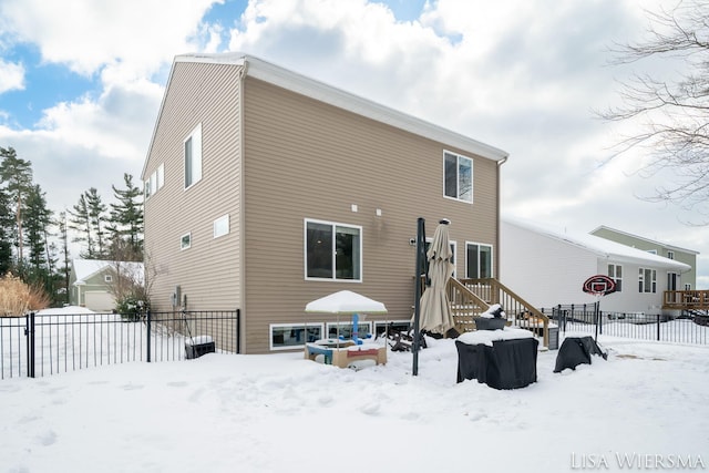 snow covered house with fence