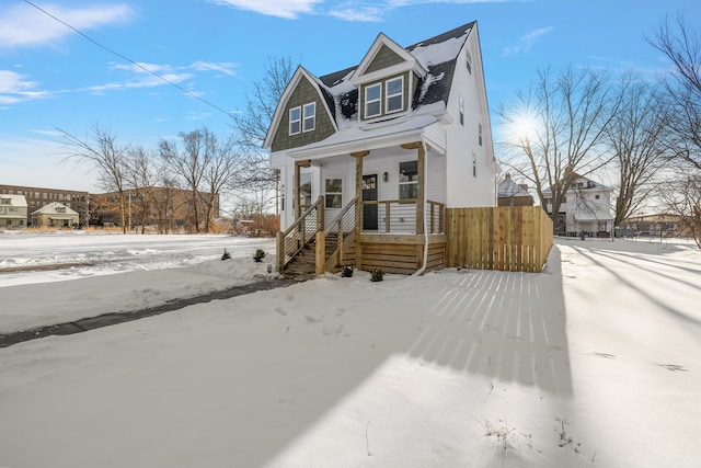 view of front of house featuring covered porch and fence