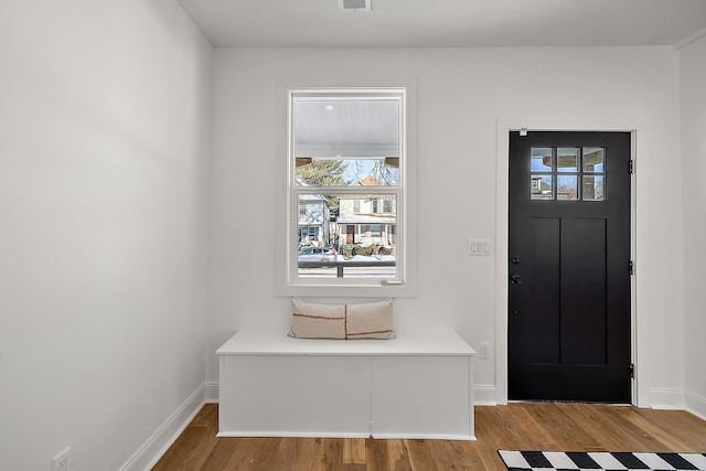 entrance foyer with wood finished floors, visible vents, and baseboards