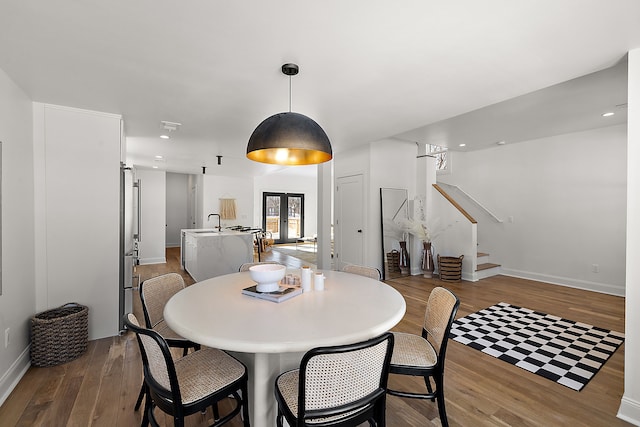 dining area with recessed lighting, wood finished floors, baseboards, french doors, and stairway