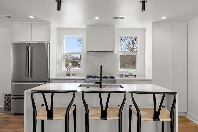 kitchen featuring light countertops, high quality fridge, modern cabinets, and visible vents