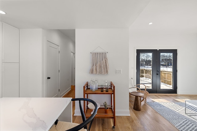 interior space featuring light wood finished floors, recessed lighting, baseboards, and french doors