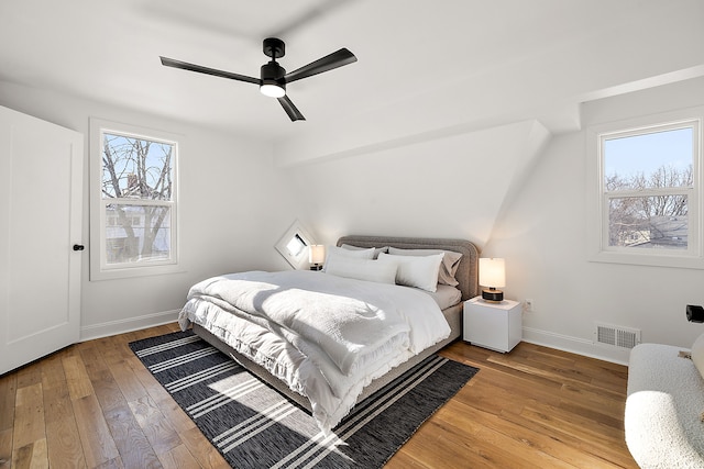 bedroom featuring baseboards, visible vents, ceiling fan, and light wood finished floors