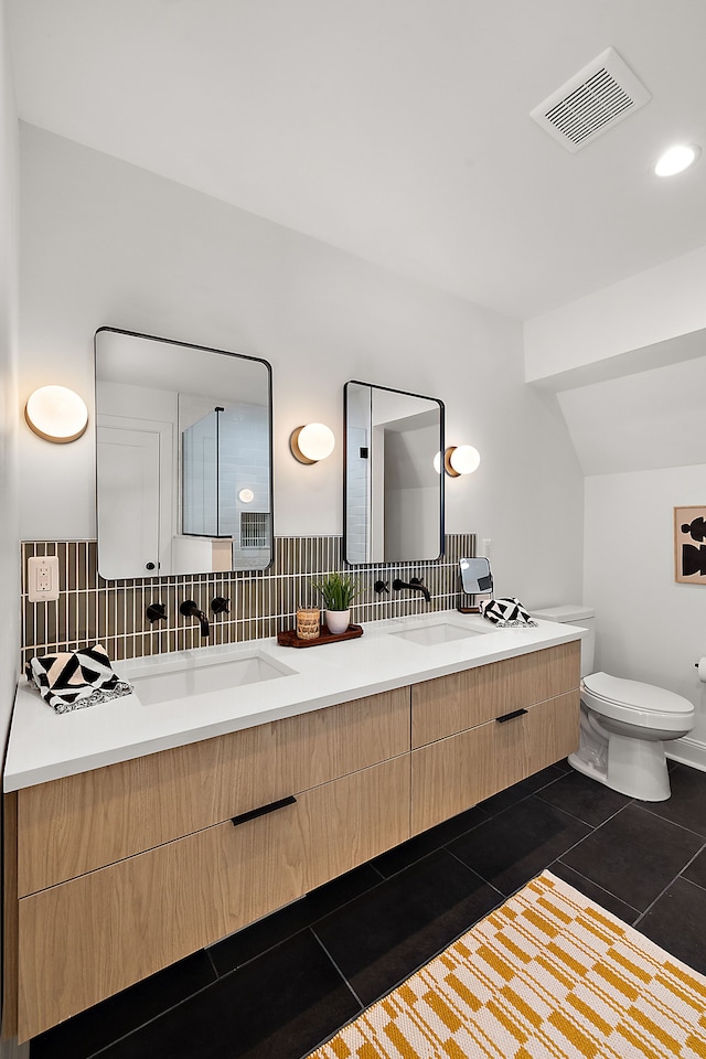 full bath featuring double vanity, visible vents, toilet, tile patterned flooring, and a sink