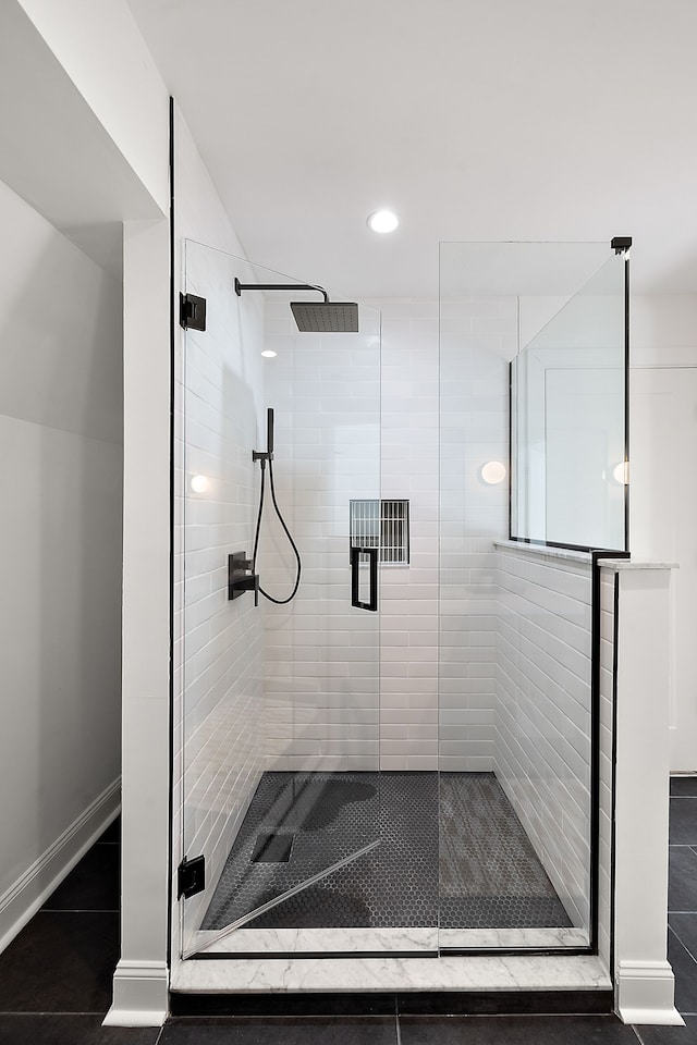 full bathroom featuring a stall shower, tile patterned flooring, and baseboards