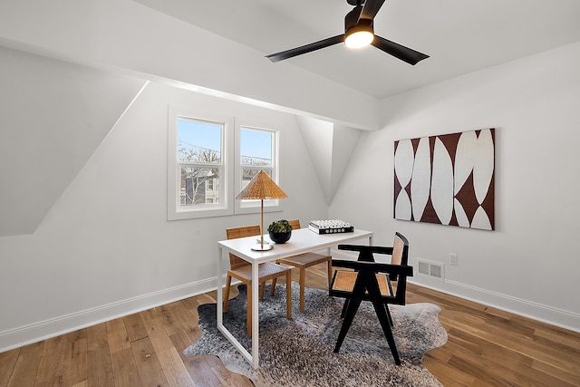 home office with hardwood / wood-style flooring, baseboards, visible vents, and a ceiling fan