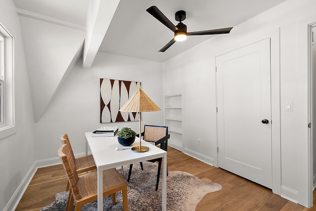 office space with ceiling fan, beam ceiling, baseboards, and wood finished floors