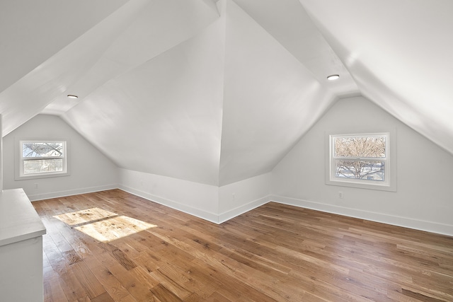 bonus room with baseboards, vaulted ceiling, and hardwood / wood-style floors