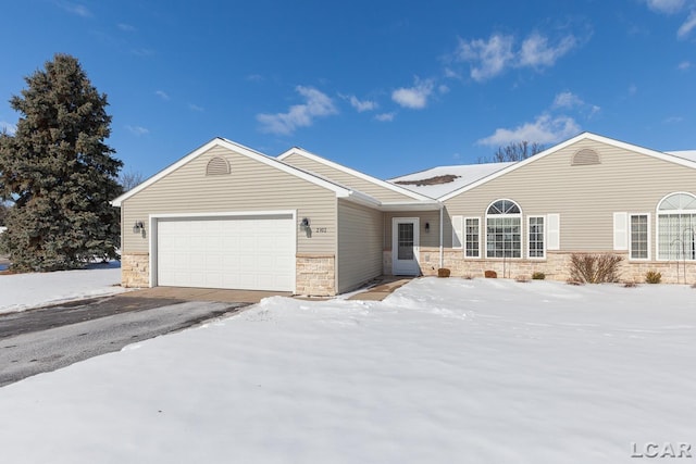 ranch-style house with a garage, stone siding, and aphalt driveway