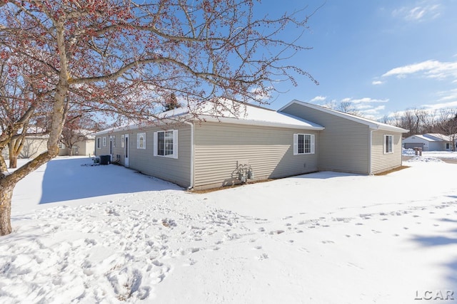 snow covered rear of property with central air condition unit