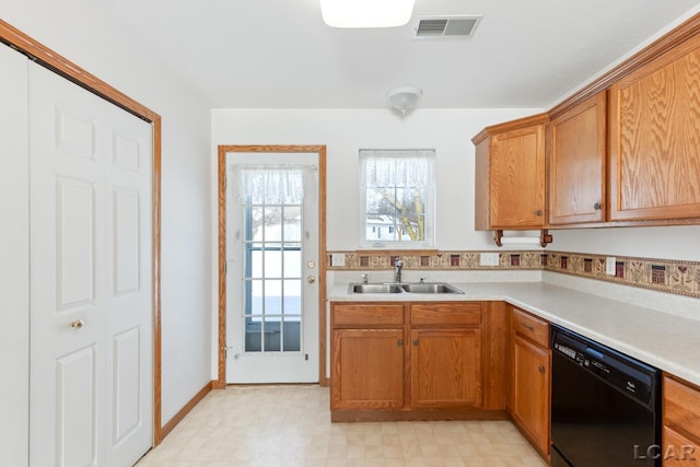 kitchen with visible vents, dishwasher, light countertops, light floors, and a sink