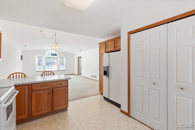 kitchen featuring white appliances, visible vents, open floor plan, light countertops, and brown cabinets